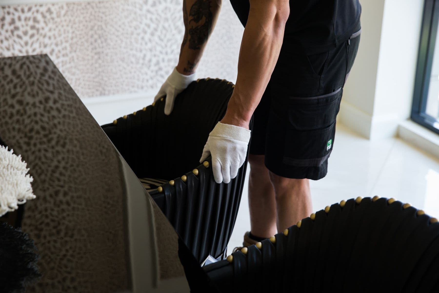 A gloved hand setting a dining chair into position.