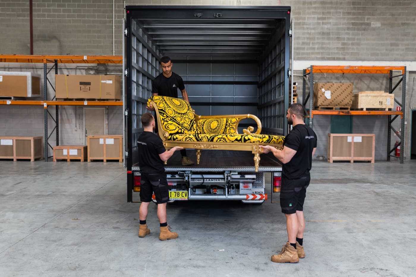 Ateam Logistics handlers loading a wrapped piece into a branded truck.