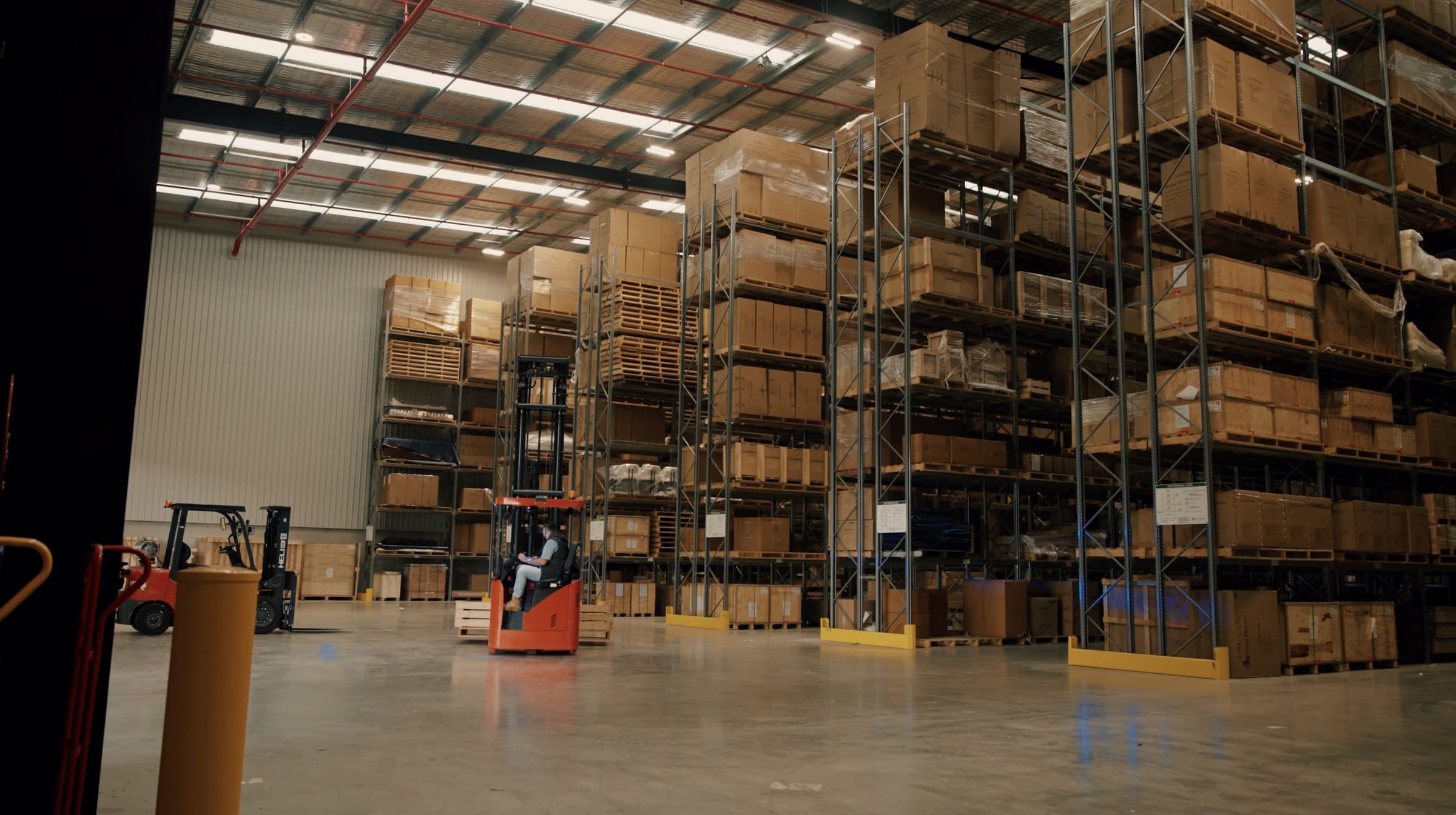 The interior of the Ateam Logistics warehouse, with steel racking holding crated and cartoned stock.
